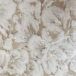 May include: White floral lace fabric with small, white sequins throughout the fabric.