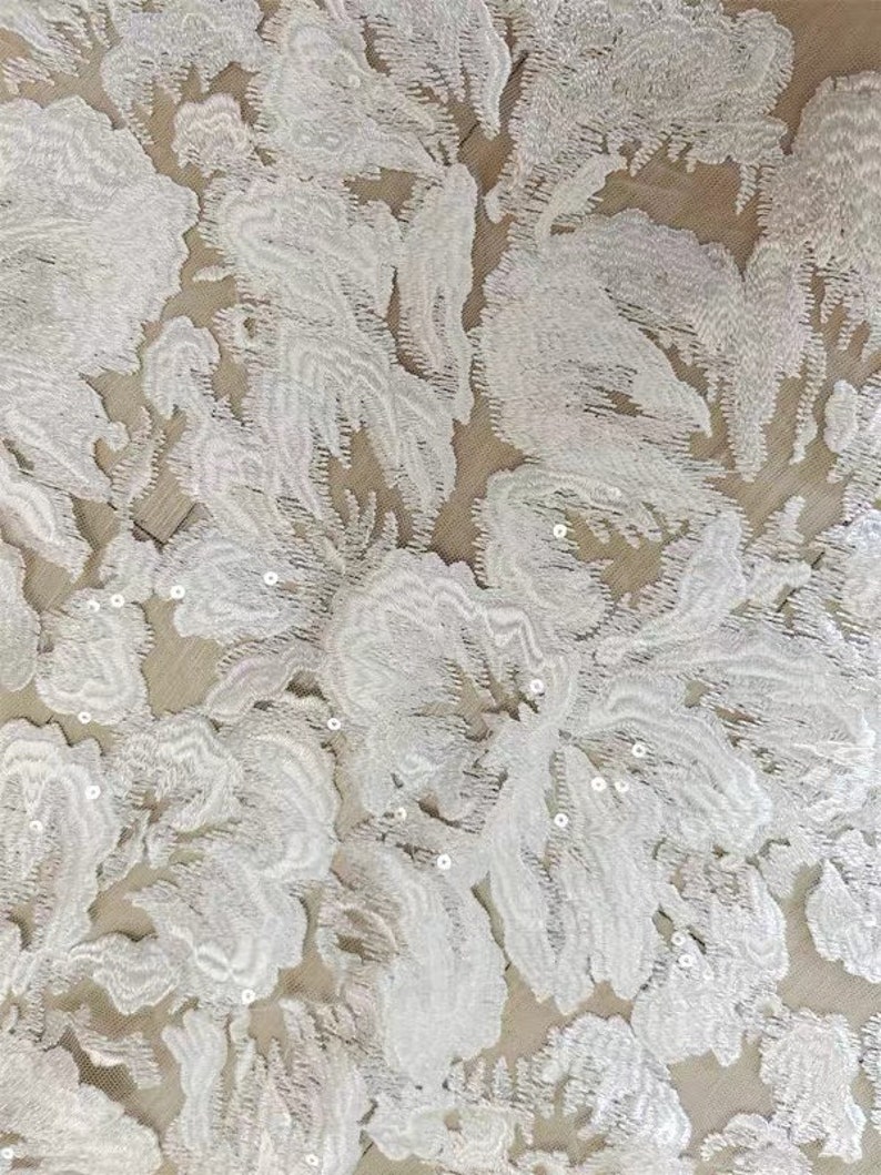 May include: White floral lace fabric with small, white sequins throughout the fabric.
