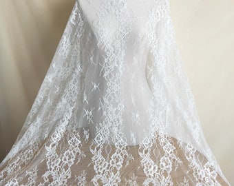 May include: White lace fabric with a delicate floral pattern. The lace is soft and sheer, making it perfect for a variety of projects.