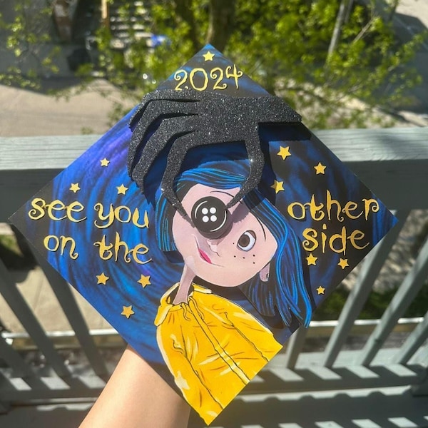 Adorno para birrete de graduación. Coraline 3D con ojos de botón