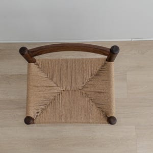 May include: A wooden chair with a woven cane seat. The chair has a dark brown finish and a simple design.