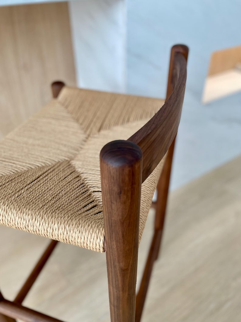 May include: A wooden chair with a woven cane seat. The chair is made of dark brown wood and has a simple, elegant design.