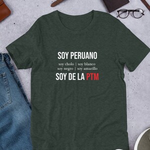 May include: A dark green t-shirt with white text that reads "SOY PERUANO soy cholo | soy blanco soy negro | soy amarillo SOY DE LA PTM".