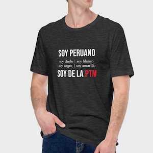 May include: A dark heather grey t-shirt with white text that reads "SOY PERUANO soy cholo | soy blanco soy negro | soy amarillo SOY DE LA PTM".