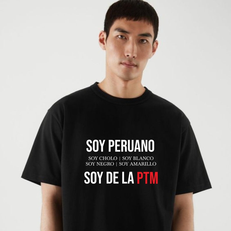 May include: Black t-shirt with white text that reads "SOY PERUANO", "SOY CHOLO | SOY BLANCO", "SOY NEGRO | SOY AMARILLO", and "SOY DE LA PTM" in red.