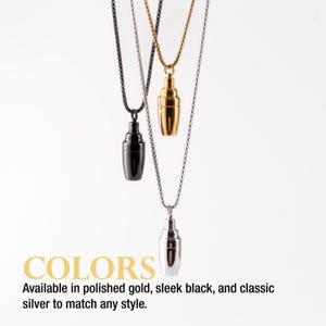 May include: Three pendant necklaces in gold, black, and silver, each featuring a cocktail shaker design. The necklaces hang against a white background. The text "COLORS" and "Available in polished gold, sleek black, and classic silver to match any style" are visible.