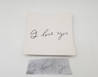 May include: White ceramic dish with a curved edge. The dish has the words "I love you" written in black cursive.
