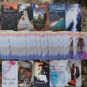 May include: A set of 48 oracle cards with colorful images and text. The cards are arranged in rows and columns on a brown tiled surface. Some of the cards show images of a wedding planner, a fireman, a spiritual healer, an artist, and a person with wings. The text on the cards includes phrases like "Own Business", "Need a Vacation", "What's My Purpose", "You Got the Job", "Seek a Career Path", and "Actor/Actress".