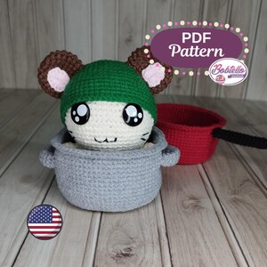 May include: Crochet amigurumi pattern for a cute mouse wearing a green hat, sitting inside a gray pot. The pattern is available as a PDF download. The image also shows a red pot.