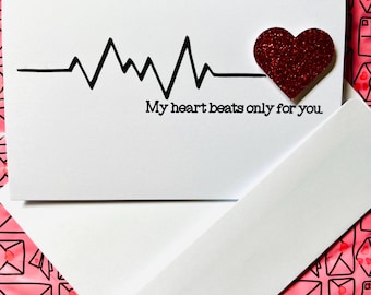May include: A white card with a black heartbeat line and a red glitter heart. The card reads "My heart beats only for you."