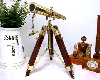 May include: A brass telescope with a wooden tripod stand. The telescope has a chain attached to the lens. The tripod has brass accents.