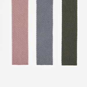 Peut inclure: Trois sangles en tissu de couleur rose, gris et vert. Les sangles sont tissées avec un motif texturé.