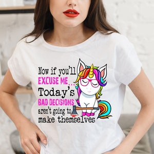 May include: A white t-shirt with a colorful unicorn graphic and the text "Now if you'll excuse me... Today's bad decisions aren't going to make themselves."