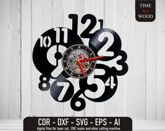 May include: A black vinyl record clock with white numbers 1 through 12. The clock is designed to look like a broken record with the numbers scattered around the clock face. The clock has a red second hand and a silver clock mechanism.