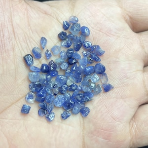 May include: A white ceramic mug with a black handle and the text "But First, Coffee" in a bold, black font. The mug is set against a neutral background, highlighting its simple design.