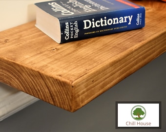 May include: A rustic wooden shelf with a natural wood finish. A blue and white Collins Pocket English Dictionary is sitting on the shelf.