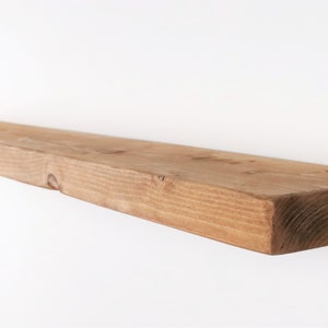 K&ouml;nnte beinhalten: Ein Regal aus Naturholz mit rustikalem Finish. Das Regal ist aus massivem Holz gefertigt und hat eine nat&uuml;rliche Maserung. Es ist perfekt, um jedem Raum einen Hauch von rustikalem Charme zu verleihen.