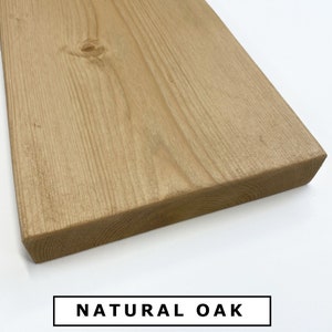 Op de afbeelding: Close-up van een naturel eikenhouten plank. Het hout heeft een lichtbruine kleur en een gladde afwerking. De nerf van het hout is zichtbaar. NATURAL OAK is in zwarte tekst op een witte achtergrond gedrukt.