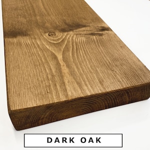 Op de afbeelding: Een close-up van een donker eikenhouten plank. Het hout heeft een rijke bruine kleur en een natuurlijk nerfpatroon. De plank is glad en gepolijst.