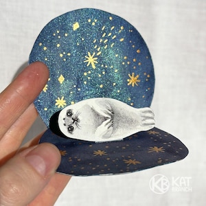 Postal de papel con acuarela hecha a mano y exclusiva en 3D con una linda foca (selkie) en una concha. Tarjeta en miniatura, tarjeta emergente, tarjeta de cumpleaños