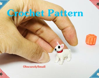 May include: A miniature white crochet dog with black spots and a red collar. The image also features a small orange object and the words "Crochet Pattern" in blue. The Etsy shop name "ObscurelySmall" is also visible.