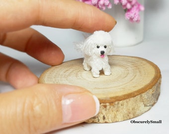 May include: A small white crocheted dog figurine with a pink tongue sticking out, standing on a wooden round slice. The dog is about 1 inch tall.