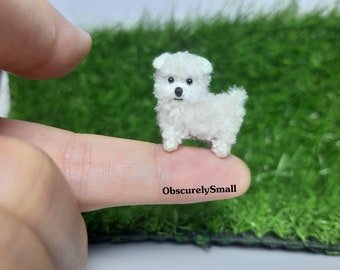 May include: A small white crocheted dog figurine, standing on a finger. The dog has black eyes and a black nose.