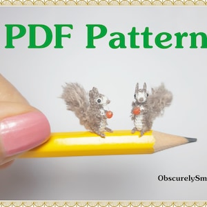 Puede incluir: Patrón PDF para tejer dos ardillas en miniatura que sostienen pequeñas manzanas rojas. Las ardillas están sentadas en un lápiz amarillo. El texto "PDF Pattern" está en letras verdes en la parte superior de la imagen. El texto "ObscurelySmall" está en la parte inferior de la imagen.