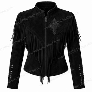 May include: A black jacket featuring a front zip closure, a high collar, and long fringe detailing across the chest and shoulders. The garment includes an embroidered cross design on the upper right chest and lace-up accents on the cuffs.