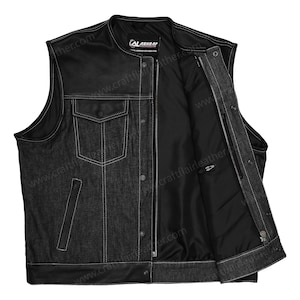 May include: A black denim vest featuring leather shoulder panels and a leather bottom hem. The vest includes a front zipper closure, snap buttons, a chest pocket with a flap, and two side pockets. The interior is lined with black fabric.