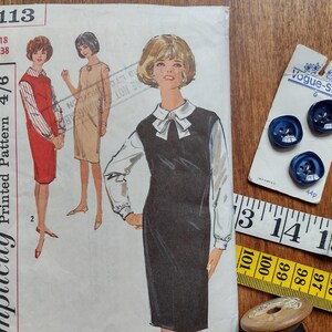 May include: A vintage sewing pattern for a dress, Simplicity pattern number 5113, size 18, bust 38. The pattern is for a sleeveless dress with a white collar and a black skirt. The pattern is printed on white paper with black text.