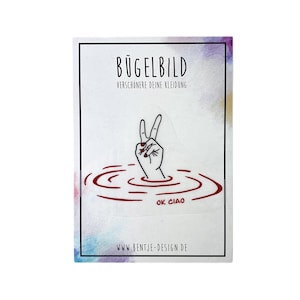 Könnte beinhalten: Bügelbild mit einer schwarzen Linienzeichnung einer Hand, die ein Peace-Zeichen macht, teilweise in rotes Wasser getaucht mit dem Text "OK CIAO" in rot. Das Bügelbild ist auf weißem Hintergrund mit dem Text "BÜGELBILD VERSCHÖNERE DEINE KLEIDUNG" und "WWW.BENTJE-DESIGN.DE".