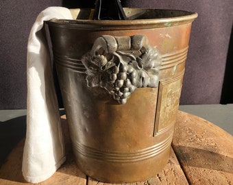 ANTIQUE  wine cooler, ice bucket, Champagne bucket. Logo on 1 side “CRISTAL St.GEORGES” 1930’s. Has had a very busy life …..