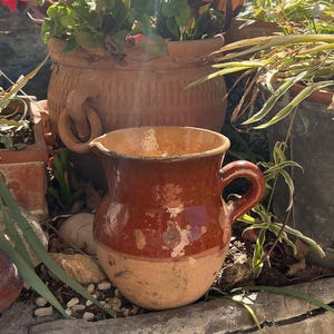 Może przedstawiać: Zestaw trzech ceramicznych kubków z nakrapianym, matowym wykończeniem. Kubki są w odcieniach kremowym, jasnoszarym i ciemnoszarym. Każdy kubek ma prosty, minimalistyczny design, idealny do kawy lub herbaty.