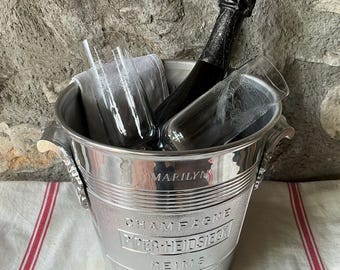 Una cubitera Piper-Heidsieck para champán dedicada a Marilyn Monroe. Tiene grabado el nombre MARILYN en un lado y su dirección de Nueva York en el otro.