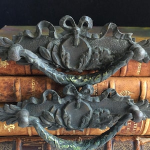 May include: A white ceramic mug with a black handle and the text "But First, Coffee" in a black, bold font. The mug is on a white surface.