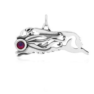 May include: Silver charm pendant featuring a detailed mermaid design with a red gemstone eye. The mermaid is depicted with flowing hair and a tail.