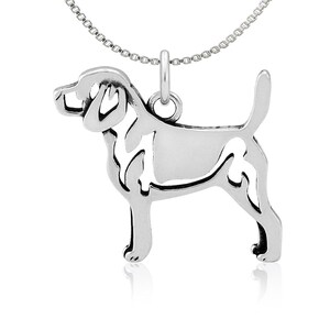 May include: Sterling silver necklace featuring a cutout design of a Beagle dog. The chain is a delicate silver box chain.