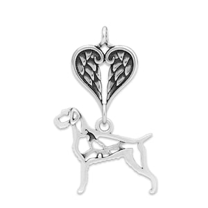 Könnte beinhalten: Ein silberner Anhänger mit einer Hunde-Silhouette unter einem herzförmigen Design mit flügelartigen Details. Der Anhänger hat eine Schlaufe oben zum Aufhängen, ideal für eine Halskette oder ein Charm-Armband. Der Hund wird in stehender Pose dargestellt.