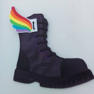May include: A purple boot patch with a rainbow wing attached. The boot has black laces and a black sole. The wing is made of colorful threads in a rainbow pattern.
