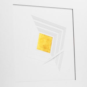 May include: A white square frame with a geometric design in gray lines. A square of gold leaf is centered in the design.