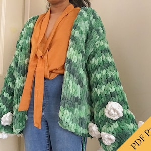 Puede incluir: Un cárdigan de crochet verde y azul con flores de crochet blancas en las mangas. El cárdigan está abierto en la parte delantera y tiene un corte holgado. ¡Patrón PDF solamente!