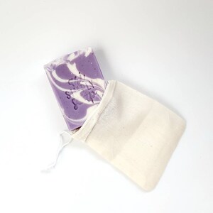 May include: A purple and white swirl soap bar with the text "The Simply Soap" in a white cotton mesh bag.