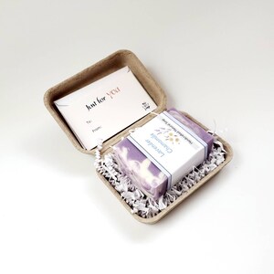 May include: A small gift box with a lavender and chamomile handmade soap inside. The box is made of brown cardboard and has a small card that says "Just for You" on it.