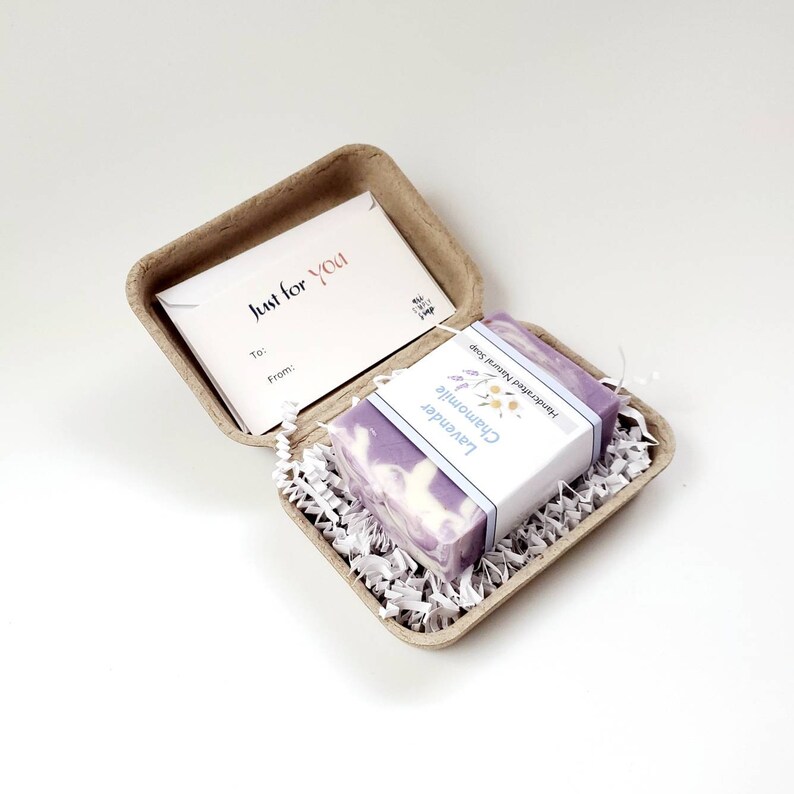 May include: A small gift box with a lavender and chamomile handmade soap inside. The box is made of brown cardboard and has a small card that says "Just for You" on it.