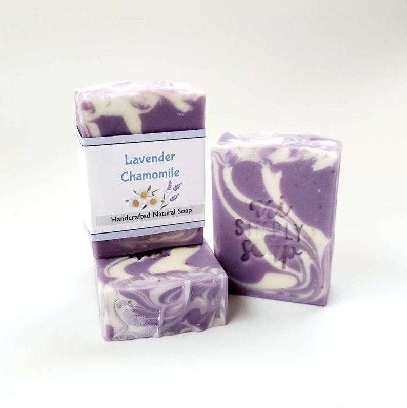 May include: Three bars of handmade lavender chamomile soap. The soap is a swirl of purple and white. The top bar has a label that reads "Lavender Chamomile Handcrafted Natural Soap".