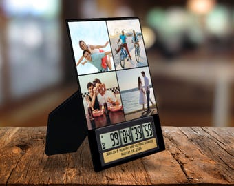 May include: Black digital countdown clock with a gold frame displaying "99 04 39 59" and the text "Jessica & Rowan are getting married August 16, 2026". The clock has a photo frame with four pictures of a couple.