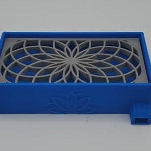 Puede incluir: Una bandeja de pl&aacute;stico azul con un dise&ntilde;o geom&eacute;trico recortado. La bandeja tiene un dise&ntilde;o de flor de loto en la parte inferior y un peque&ntilde;o pico en el lateral.