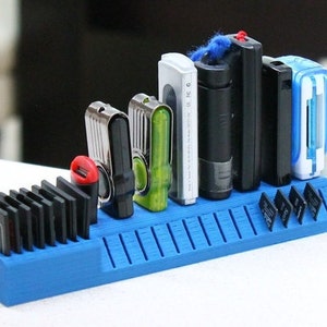 Könnte beinhalten: Ein blauer Plastik-Organizer mit Steckplätzen zum Aufbewahren von Speicherkarten und USB-Sticks. Der Organizer hat verschiedene Steckplätze in unterschiedlichen Größen, um verschiedene Arten von Speicherkarten und USB-Sticks aufzunehmen. Es befinden sich mehrere Speicherkarten und USB-Sticks im Organizer.
