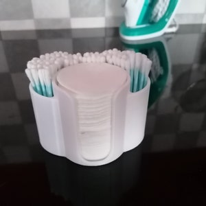 May include: White plastic organizer with two compartments for cotton swabs and a center compartment for cotton rounds. The organizer is filled with cotton swabs and rounds.